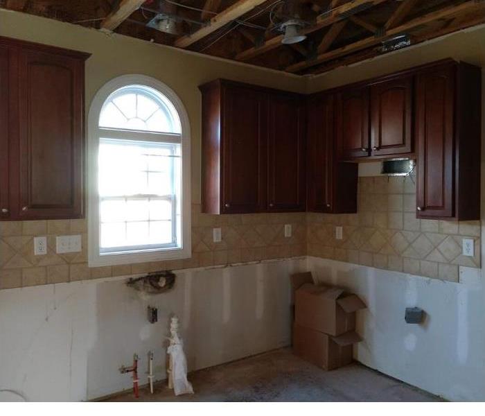 empty kitchen with cabinets torn down and no appliances.