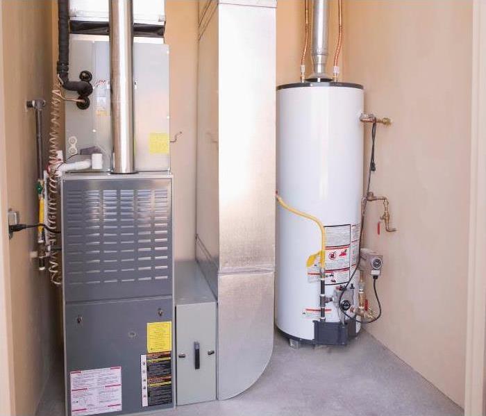 white water heater in the background with another home appliance system surrounding by cream pink walls